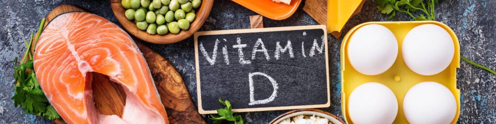 Schild Vitamin D mit Lebensmitteln auf Tisch