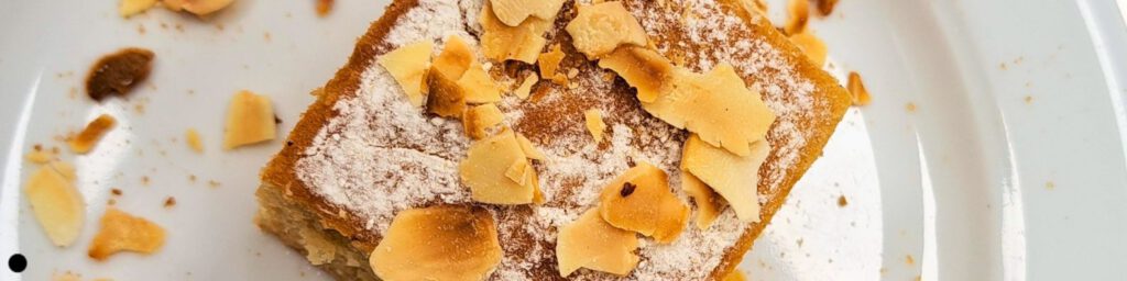 gesunder Apfelmuskuchen auf einem Teller mit gerösteten Mandelblättchen