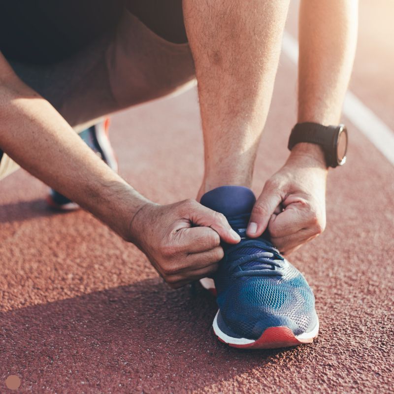 Mann bindet Schuh zum Joggen